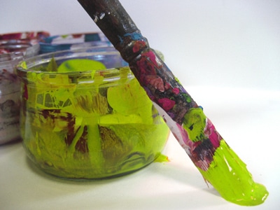 Photo d'un pot de peinture verte et d'un pinceau - ART et différences